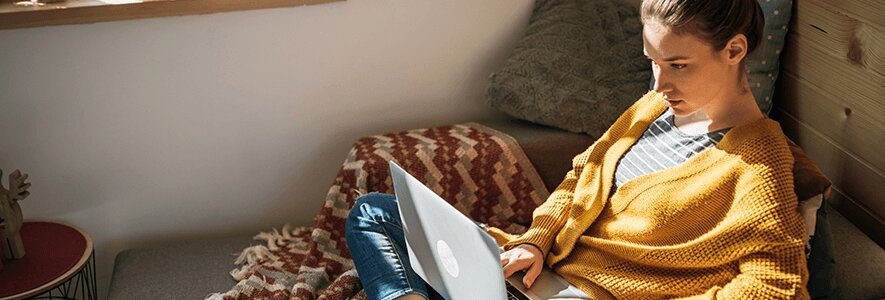 Frau am Laptop auf einem Sofa