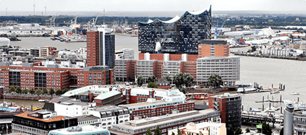 Panoramaaufnahme der Hamburger HafenCity mit der Elbphilharmonie und der Hafenkulisse.